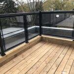 patio railing with black aluminum handrail and glass in toronto