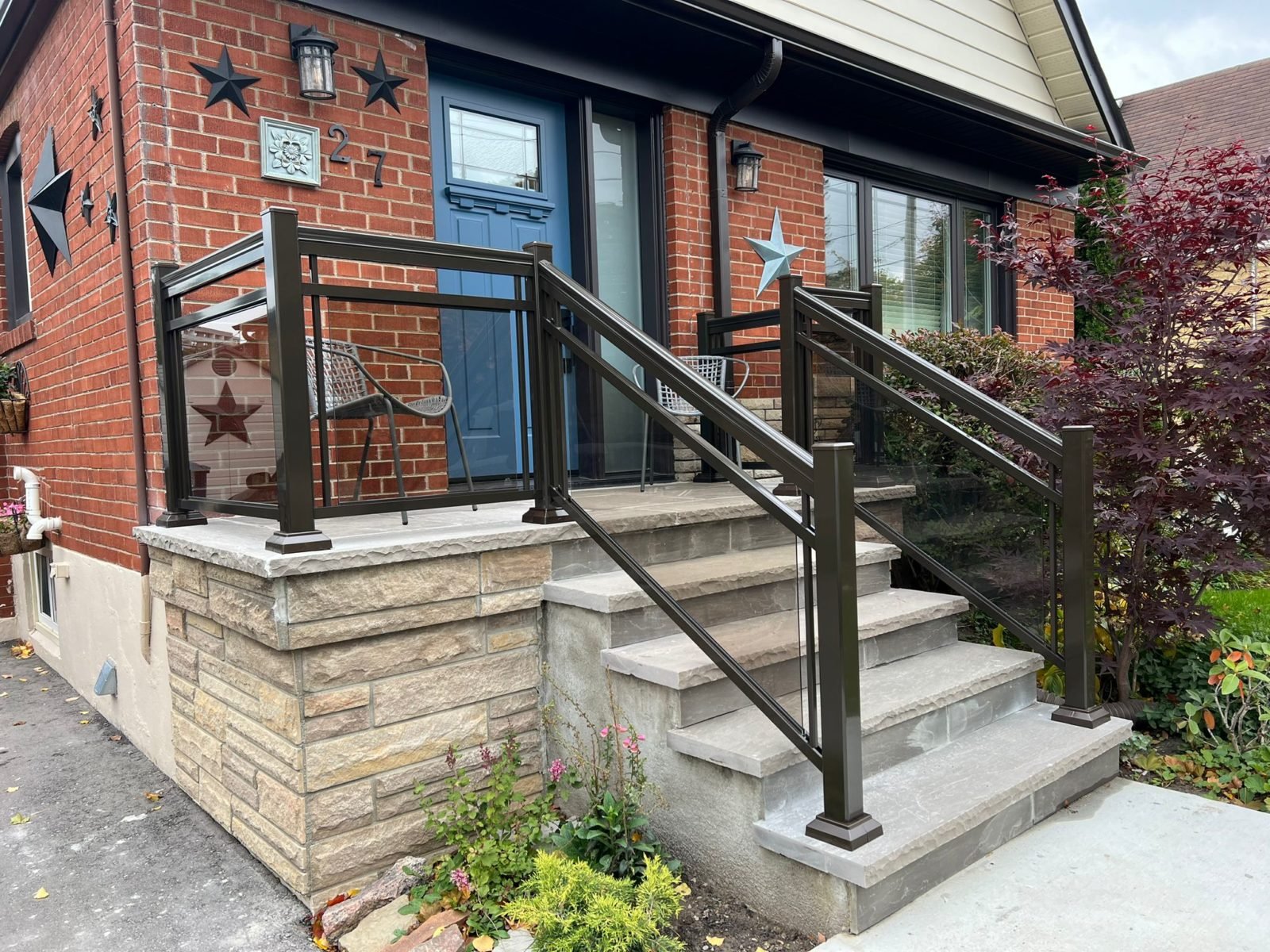 Brown aluminum porch railing with bronze glass panels, double bar style.